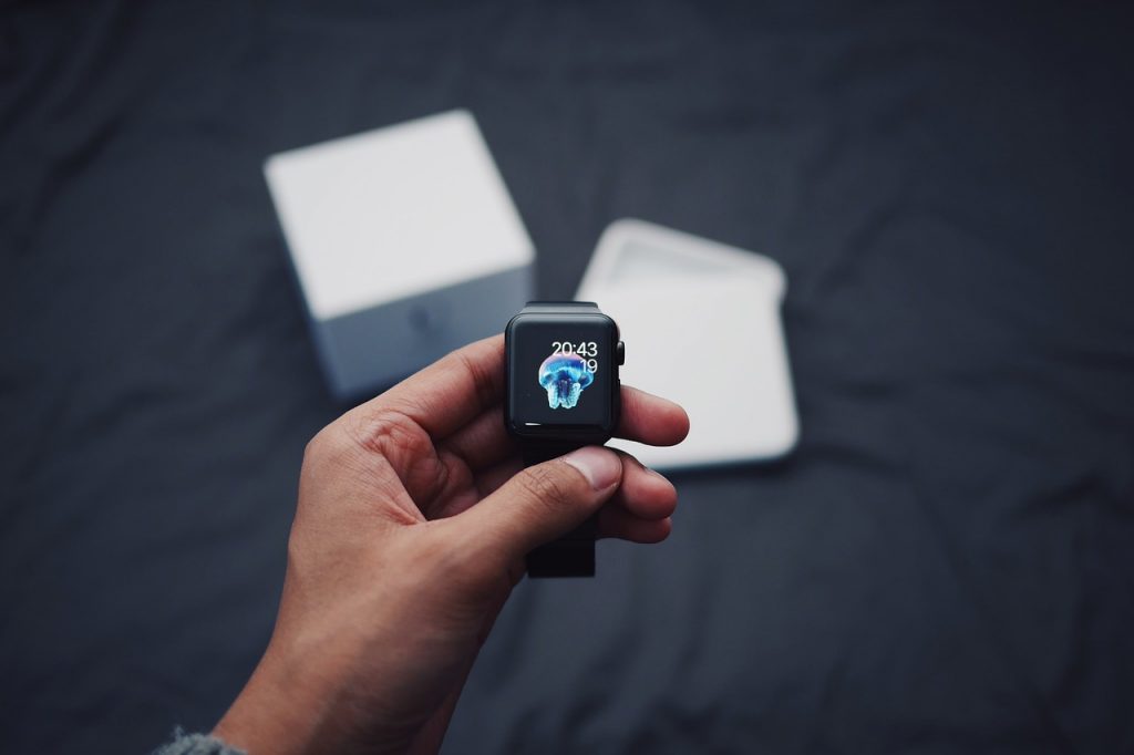 Hand holding a smart watch for mobile health purposes